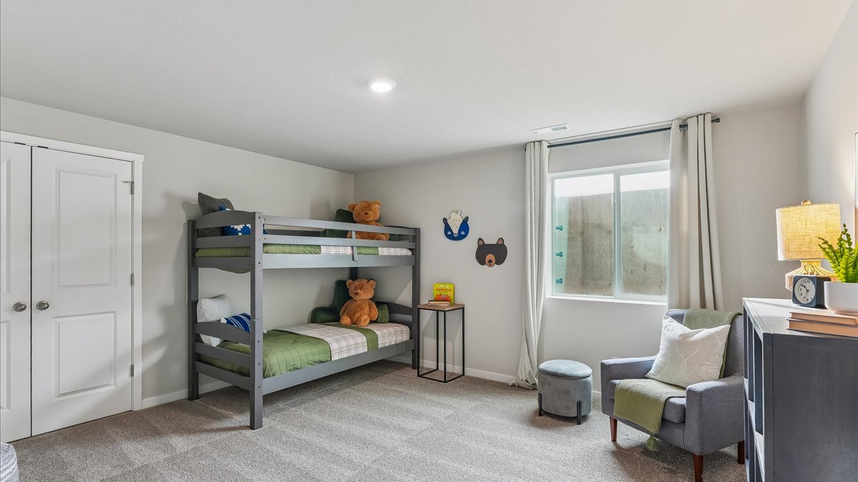 Private lower-level bedroom with natural light and functional storage space.