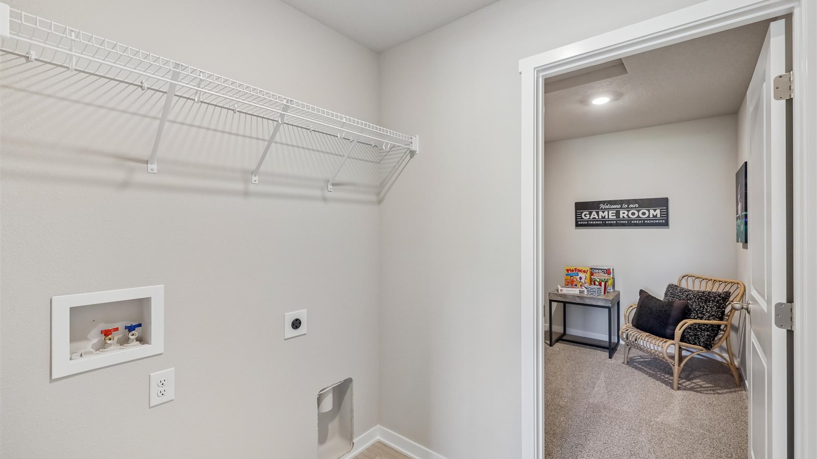 Dedicated laundry room with built-in shelving and utility connections.
