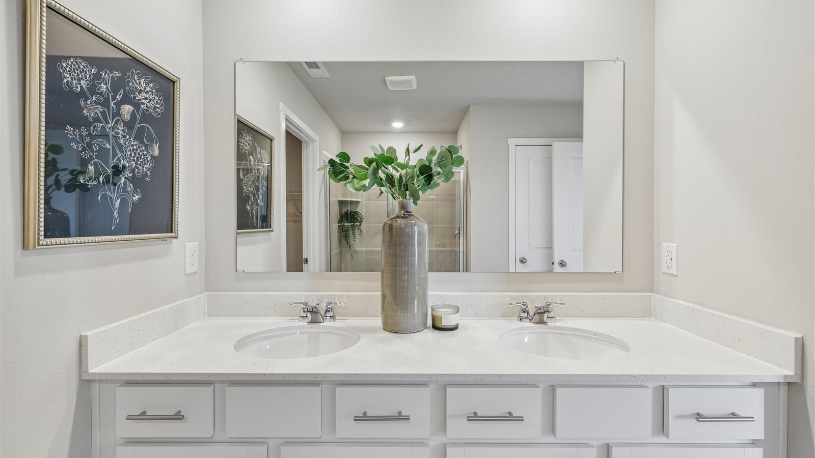 Spacious bathroom with white cabinetry and double sinks