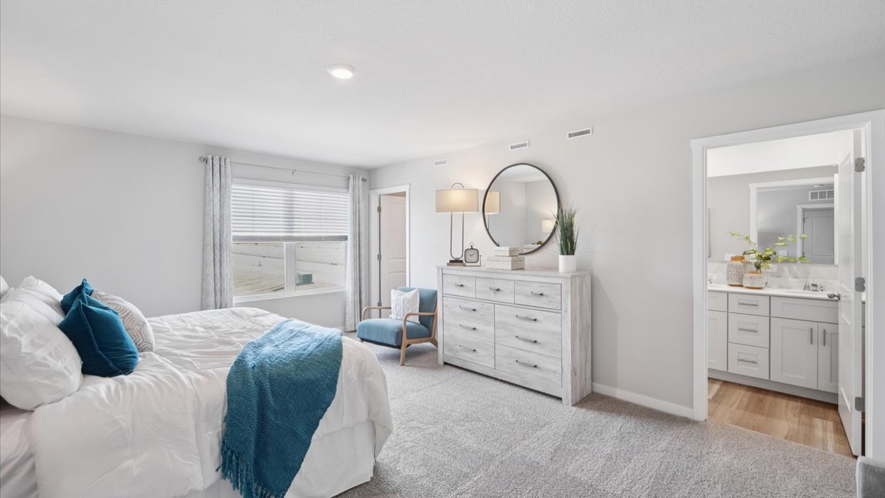 Spacious primary suite with natural light, attached bathroom, & walk in closet