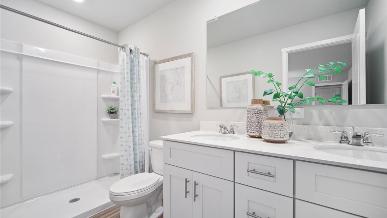 Spacious bathroom with white cabinetry and double sinks