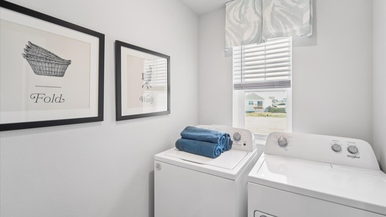 Dedicated laundry room with built-in shelving and utility connections.