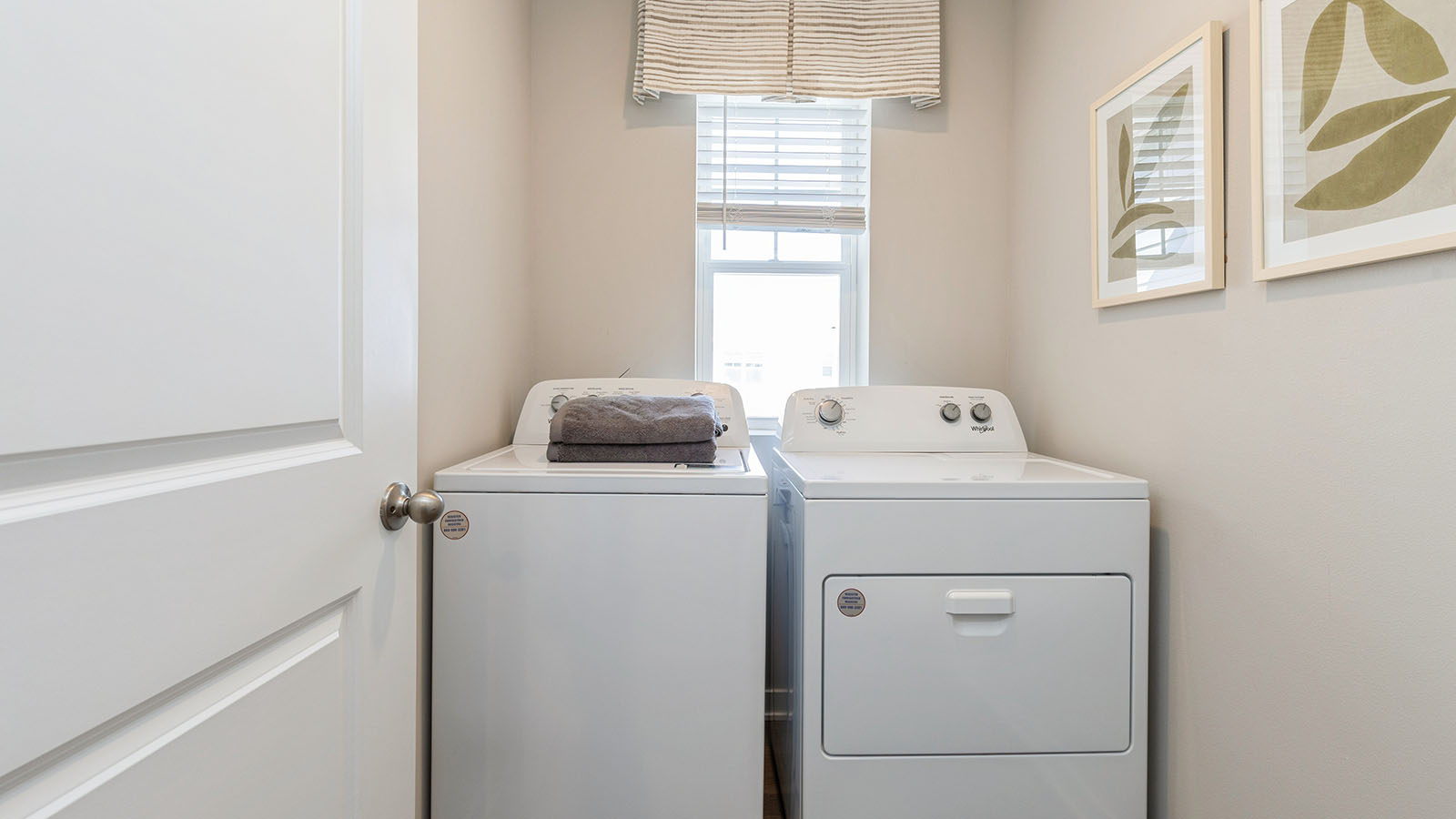 Dedicated laundry room with built-in shelving and utility connections.