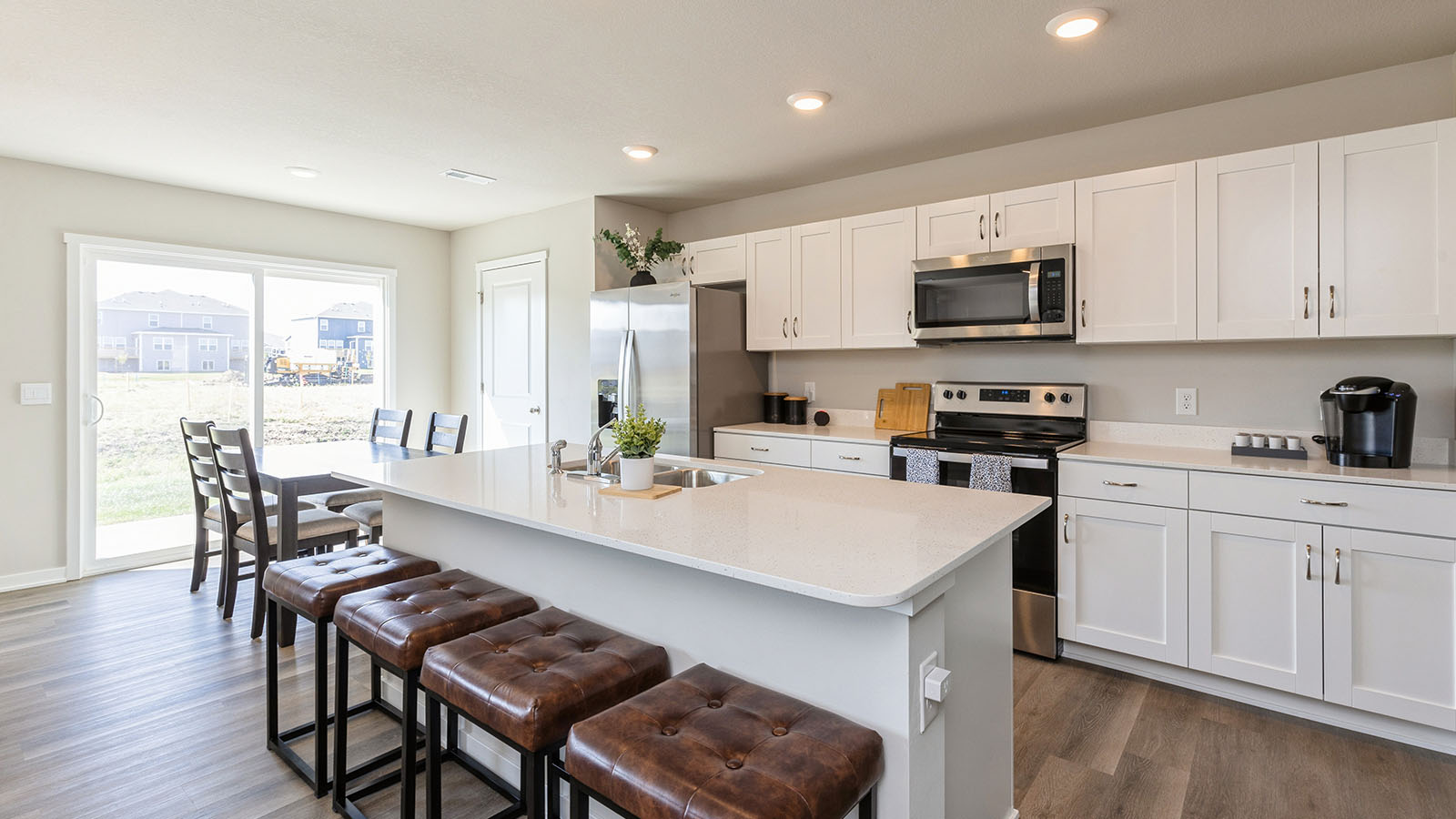 Kitchen with stainless steel appliances, quartz countertops, and white cabinetry