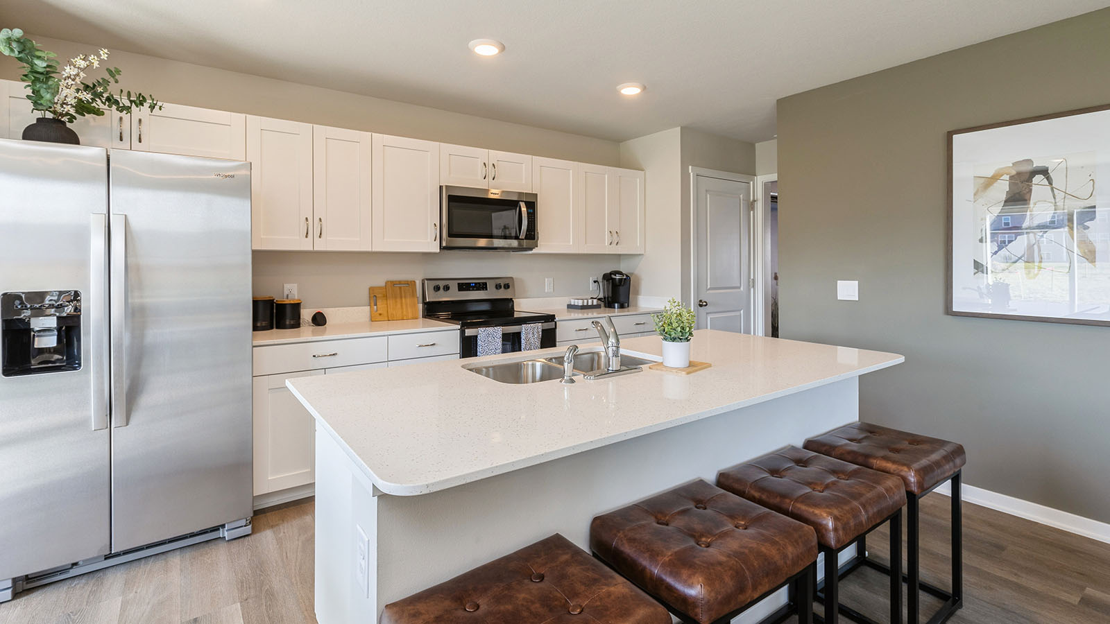 Kitchen with stainless steel appliances, quartz countertops, and white cabinetry