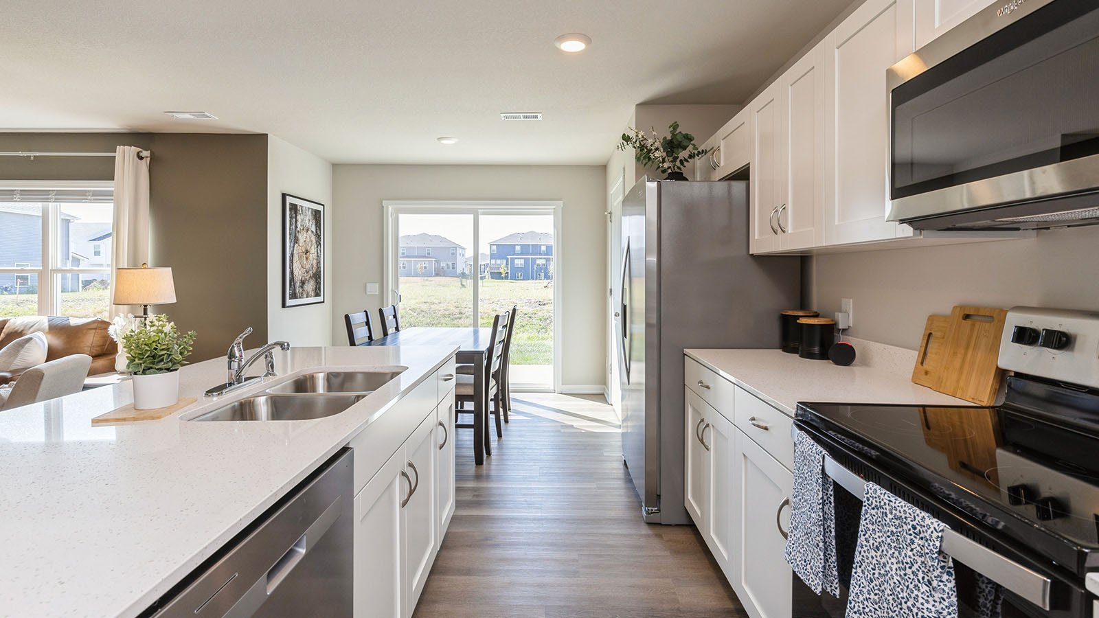 Kitchen with stainless steel appliances, quartz countertops, and white cabinetry