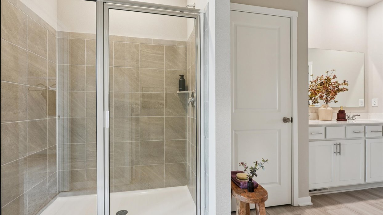 Spacious primary bathroom featuring dual vanities, modern fixtures, and a walk-in shower.