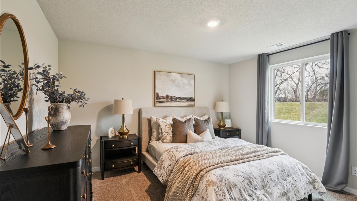 Private lower-level bedroom with natural light and functional storage space.