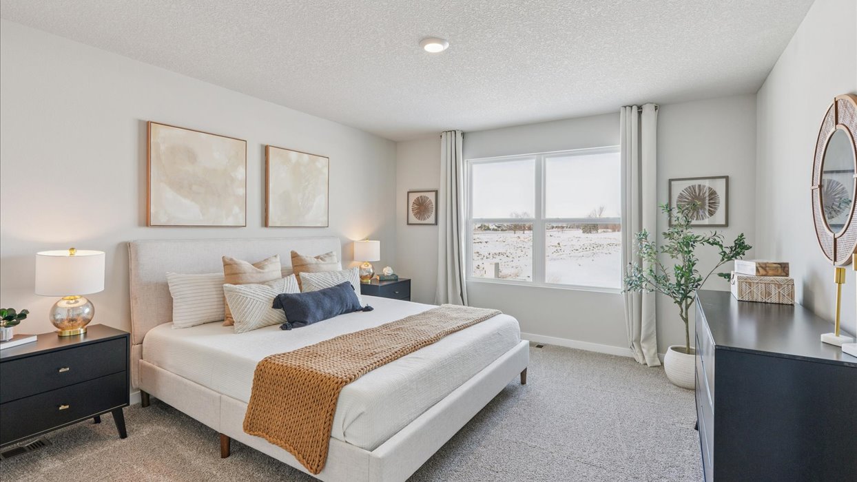 large primary bedroom with large window and white bed