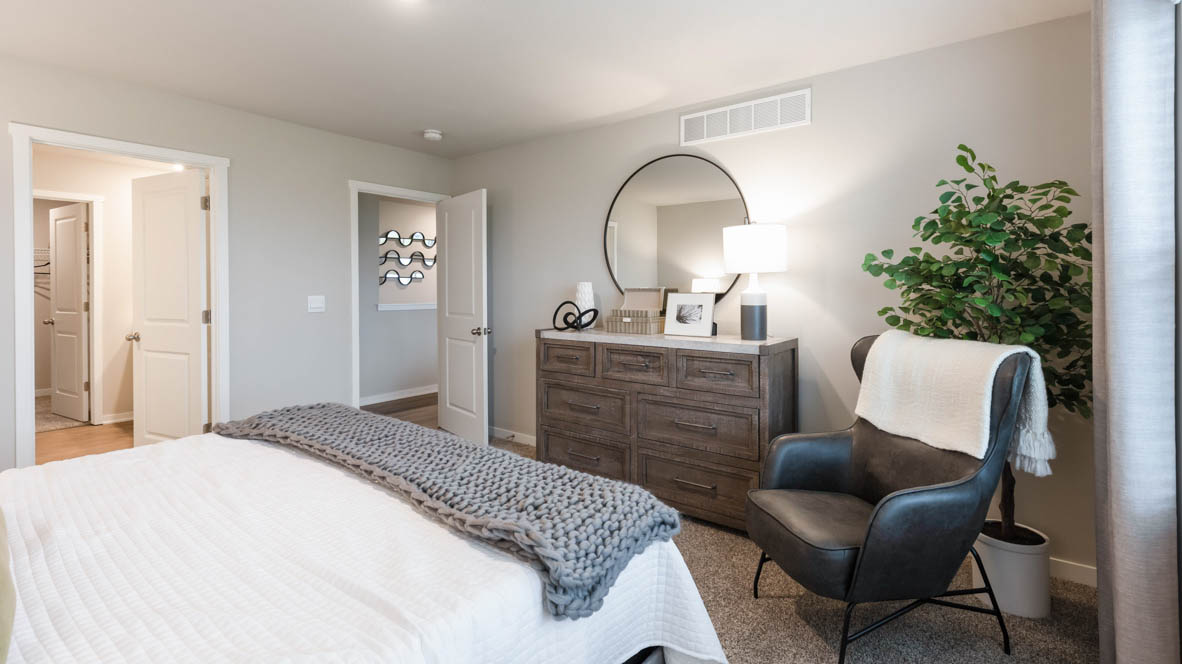 Spacious primary suite with natural light, attached bathroom, & walk in closet