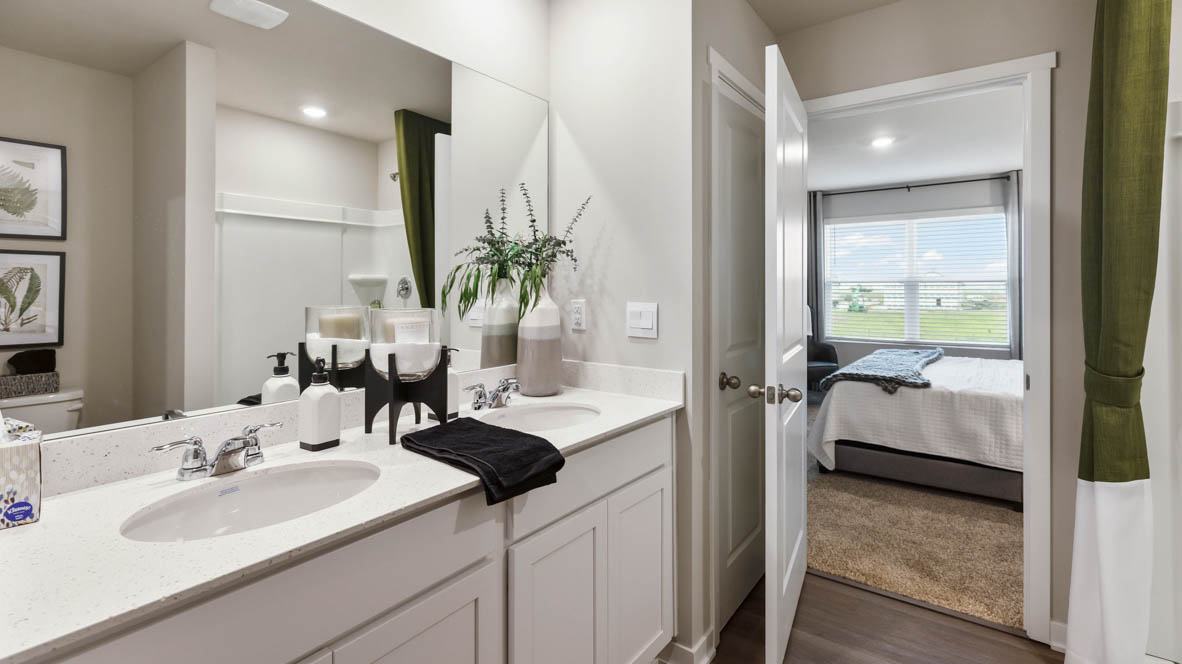 Spacious bathroom with white cabinetry and double sinks