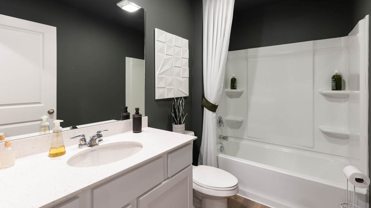 Bathroom with tub and shower combo, quartz countertops, and white vanity