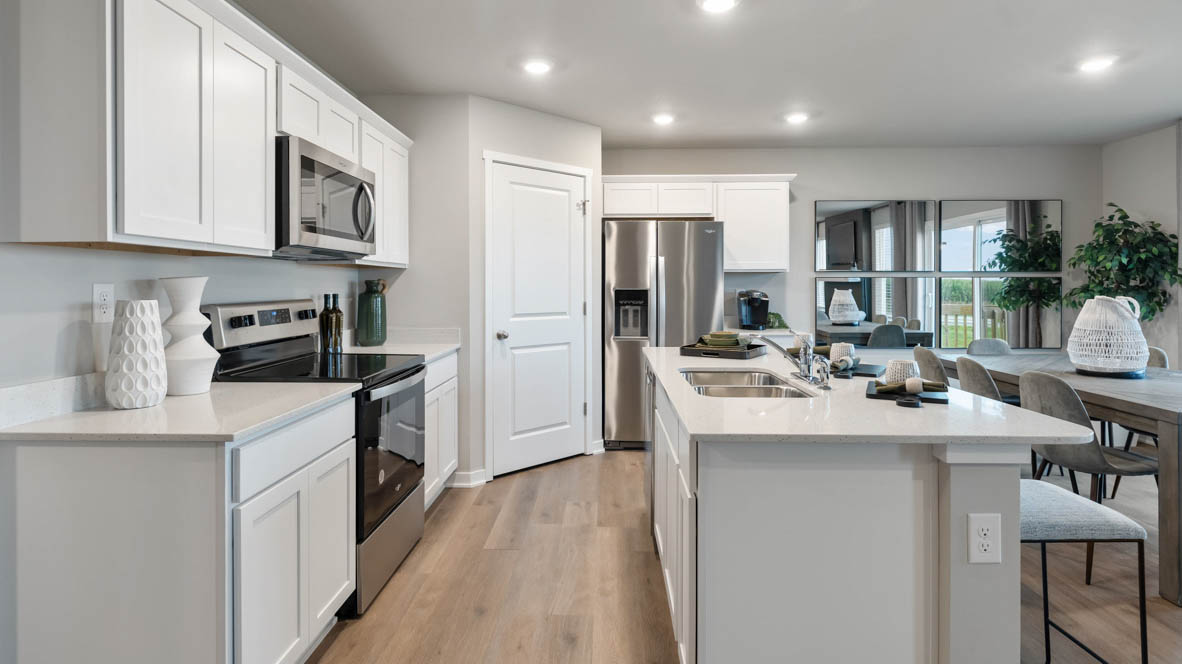 Kitchen with stainless steel appliances, quartz countertops, and white cabinetry