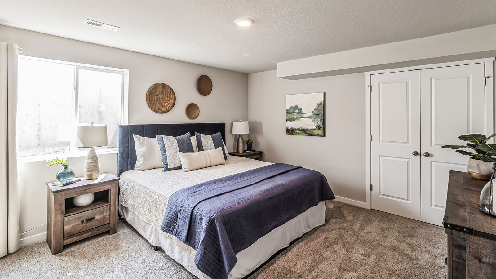 Private lower-level bedroom with natural light and functional storage space.