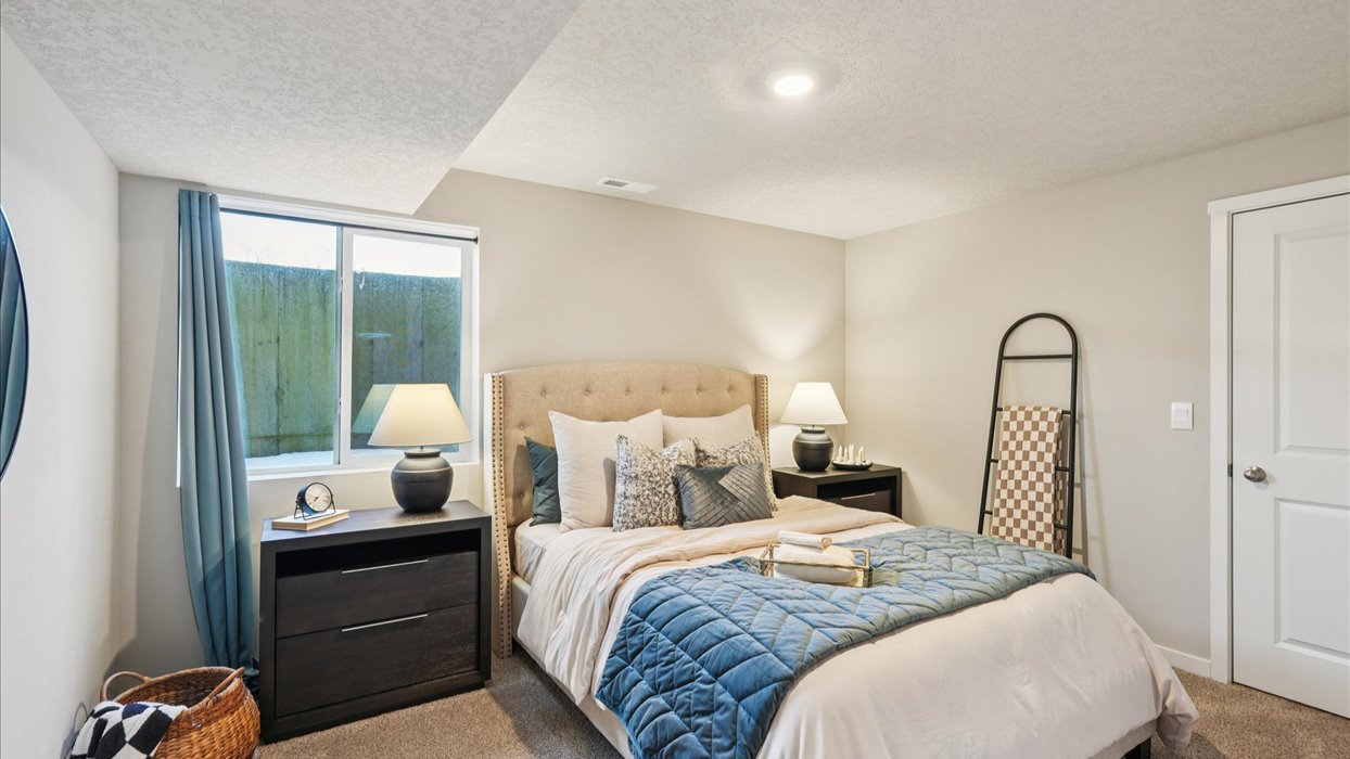 Private lower-level bedroom with natural light and functional storage space.