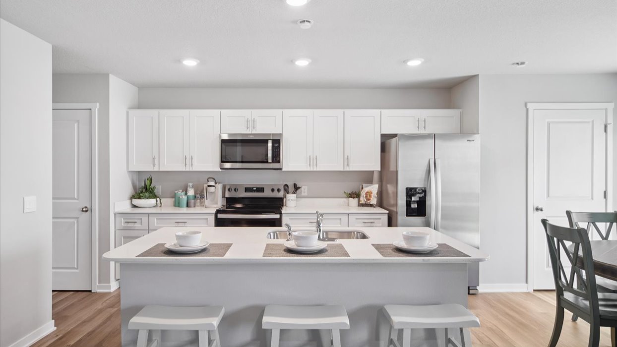 Kitchen with stainless steel appliances, quartz countertops, and white cabinetry