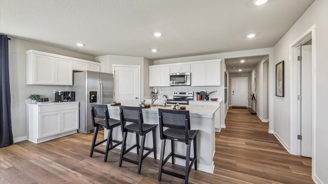 kitchen in the neuville with white cabinets and quartz countertops