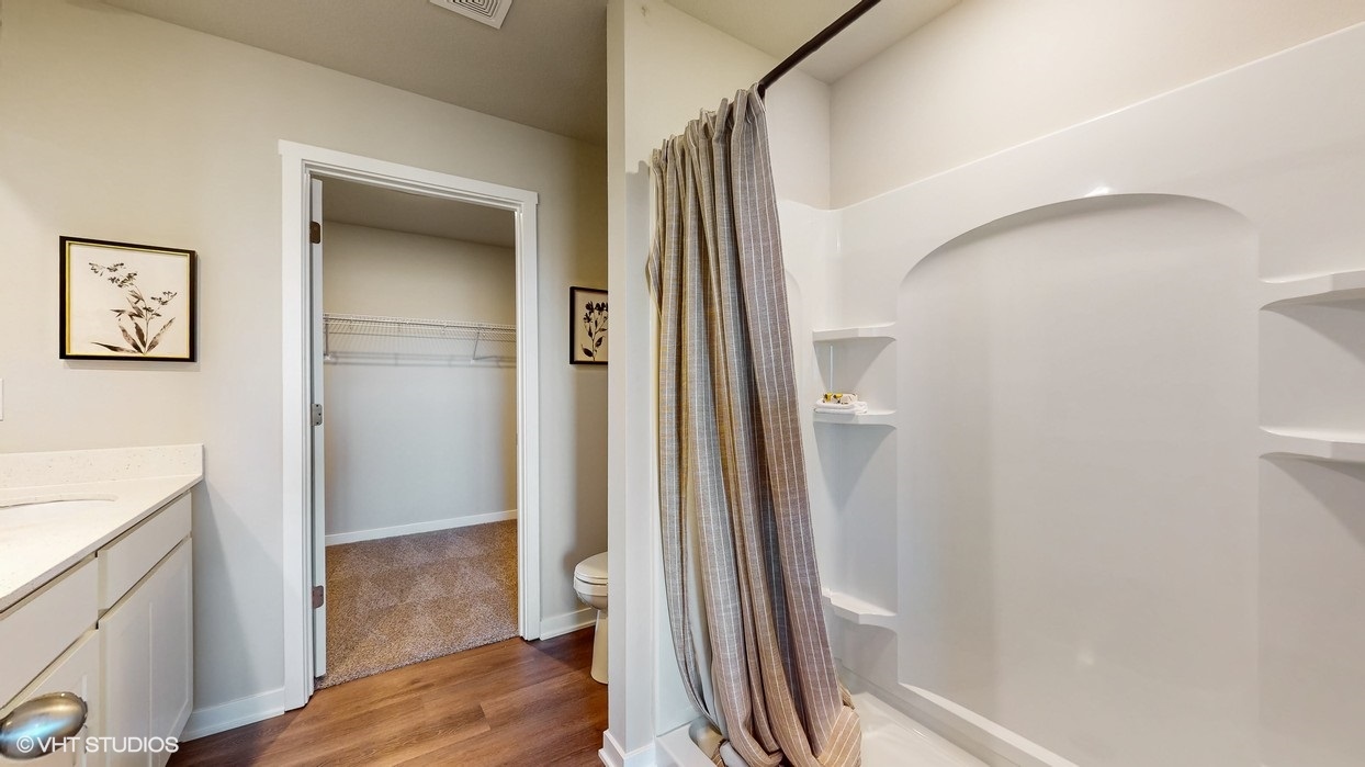 Spacious primary bathroom featuring dual vanities, modern fixtures, and a walk-in shower.