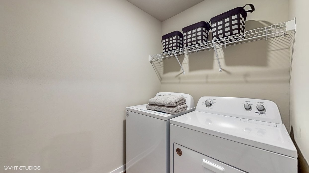 Dedicated laundry room with built-in shelving and utility connections.