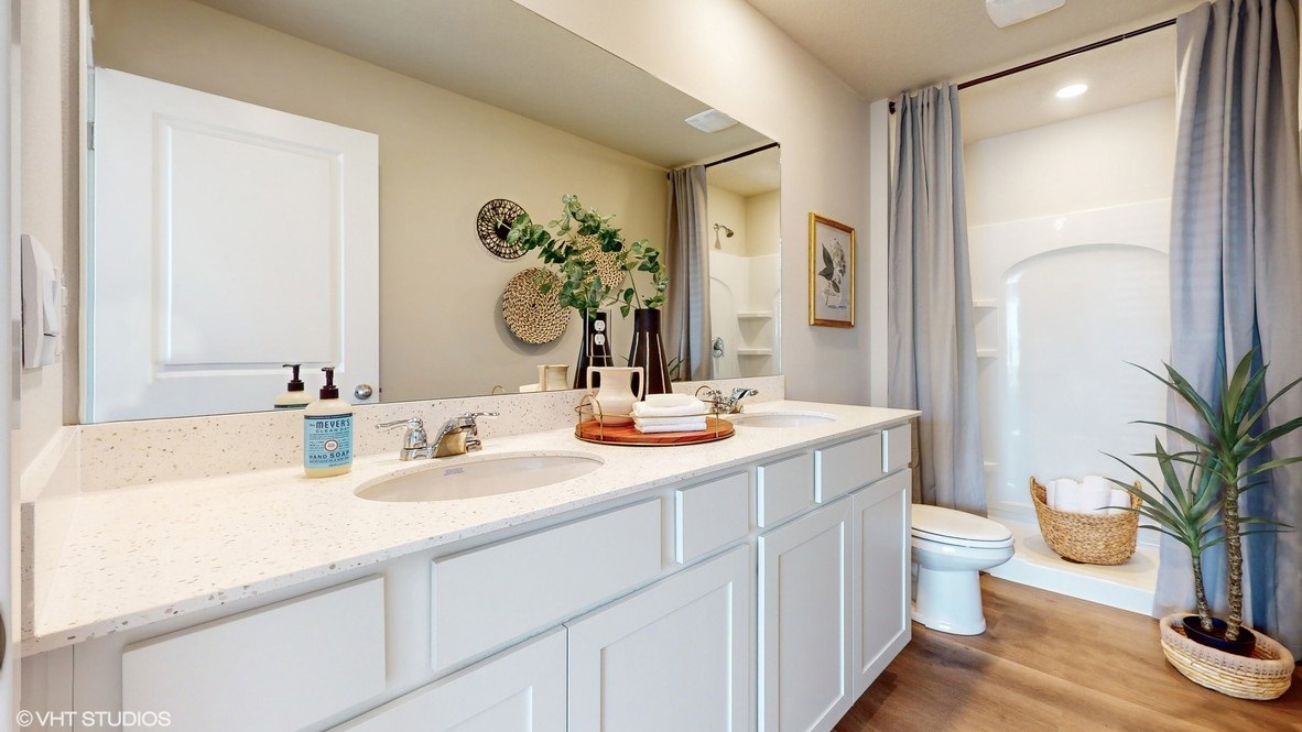 Spacious primary bathroom featuring dual vanities, modern fixtures, and a walk-in shower.