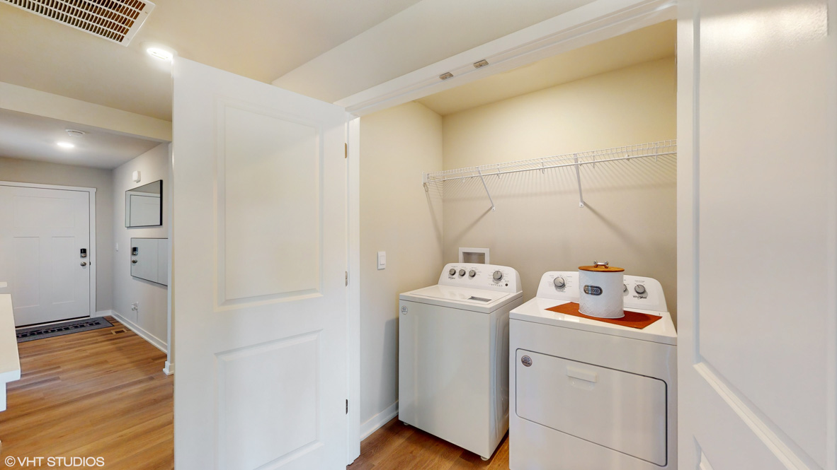 Dedicated laundry room with built-in shelving and utility connections.
