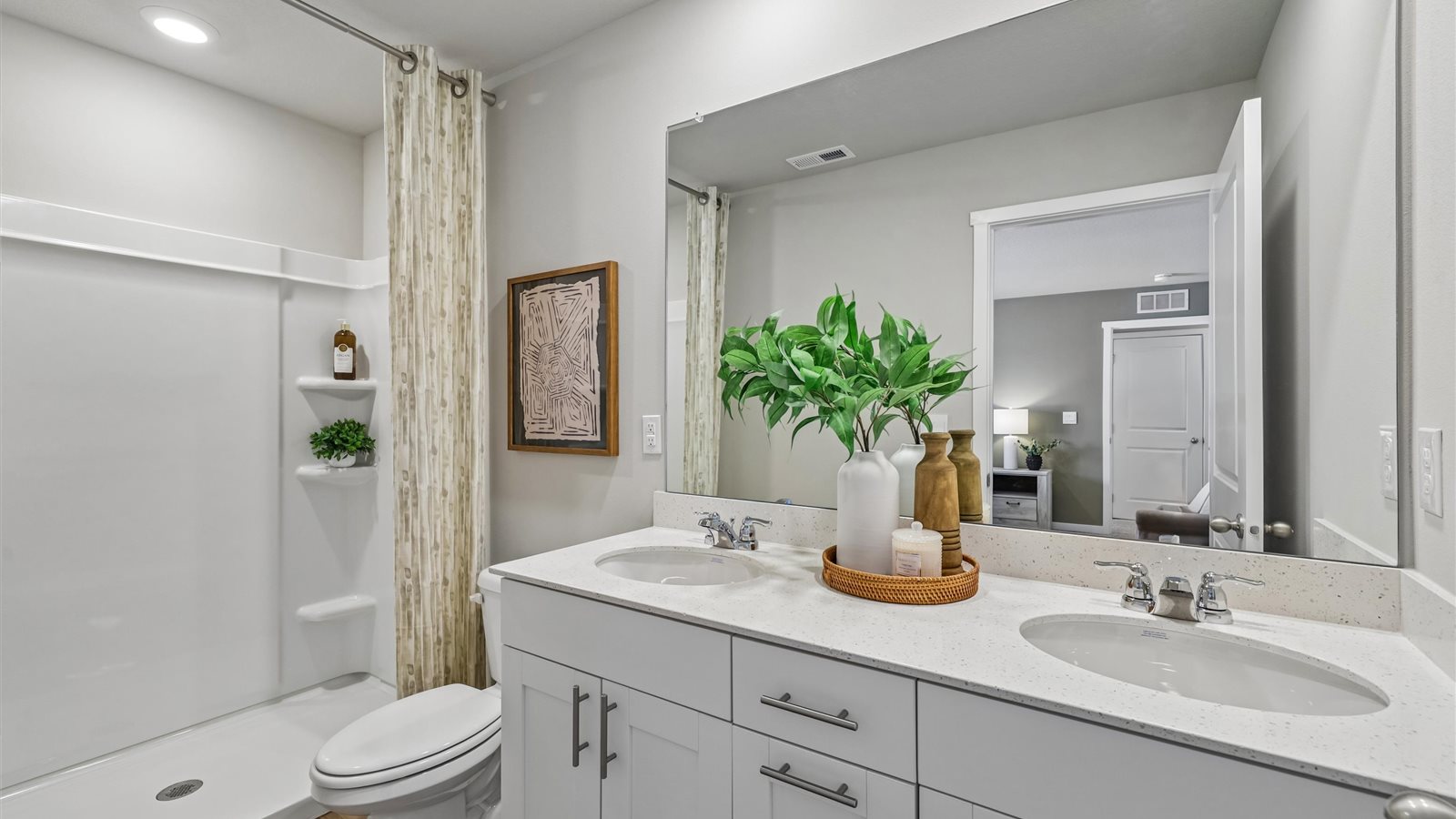 Spacious primary bathroom featuring dual vanities, modern fixtures, and a walk-in shower.