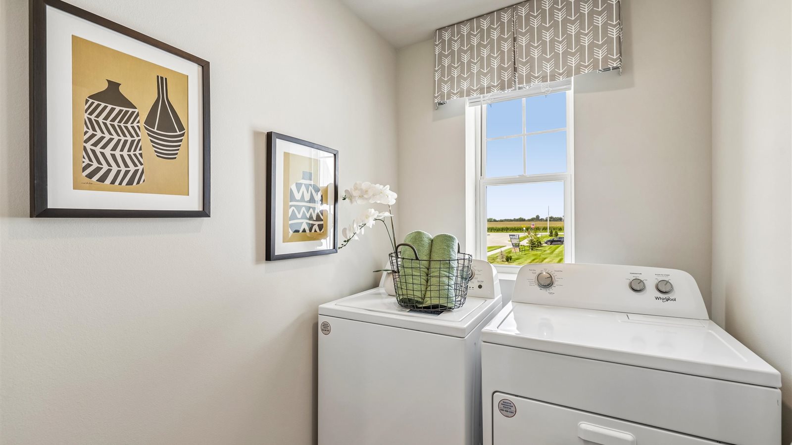 Cozy laundry space with natural light, a washer and dryer, and shelving for supplies.