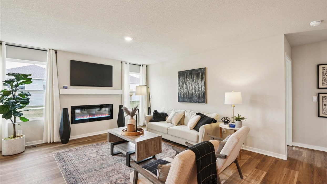 bright living room with two small windows and electric fireplace