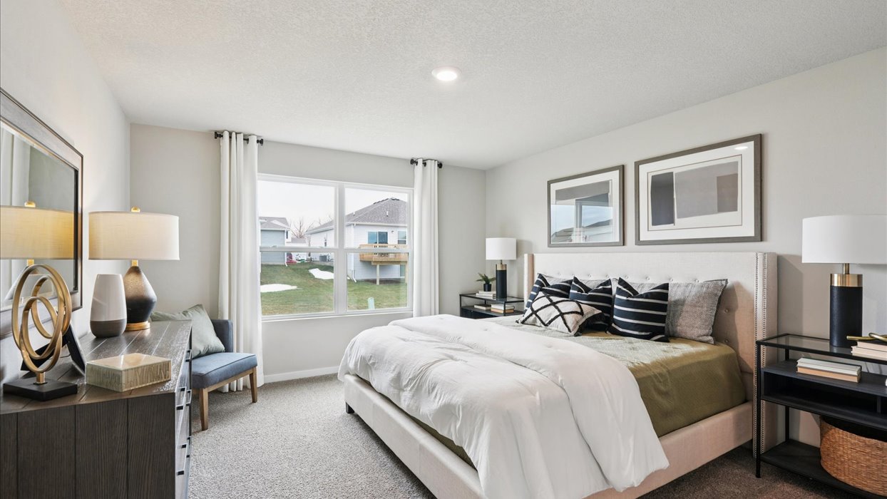 primary bedroom with large window and colorful bed