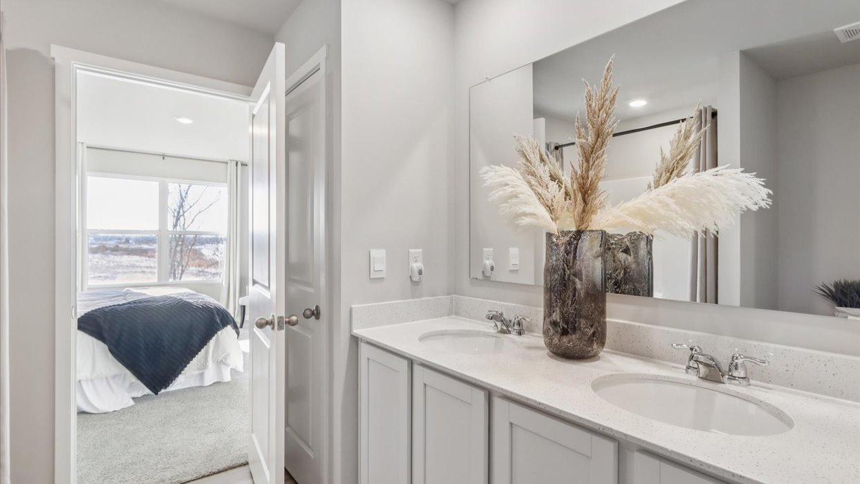 Spacious primary bathroom featuring dual vanities, modern fixtures, and a walk-in shower.