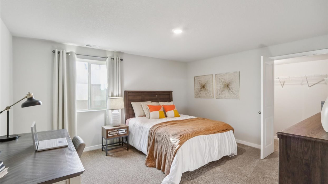 Private lower-level bedroom with natural light and functional storage space.