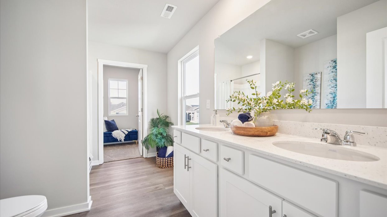primary bathroom with large mirror and dual sinks
