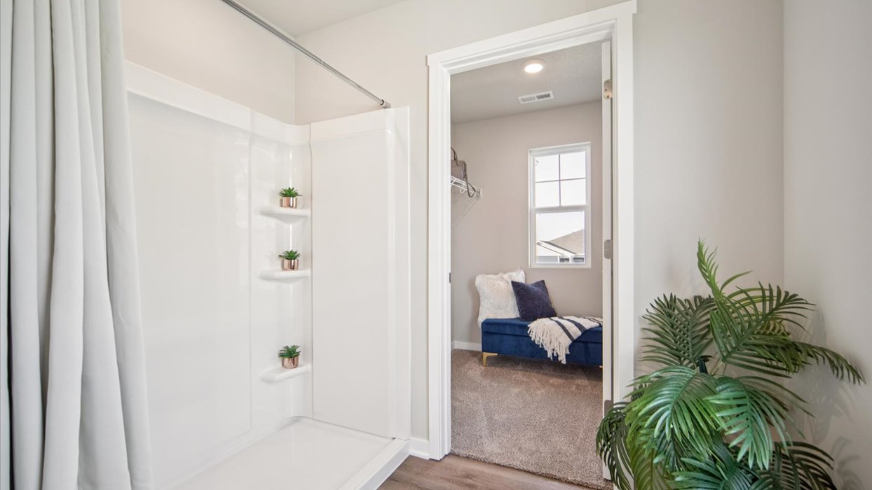 Spacious primary bathroom featuring dual vanities, modern fixtures, and a walk-in shower.