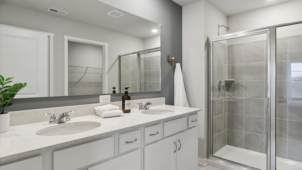 Spacious bathroom with white cabinetry and double sinks