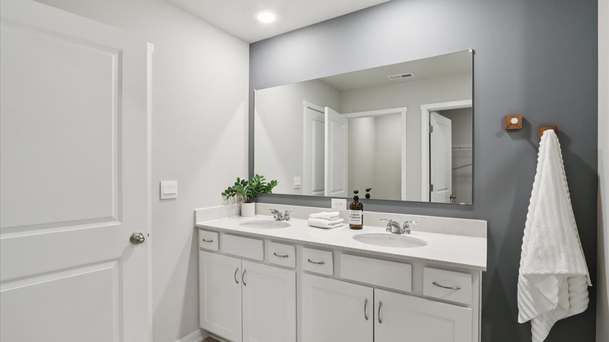 Spacious bathroom with white cabinetry and double sinks