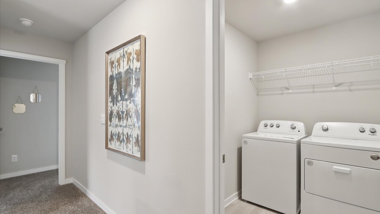 Dedicated laundry room with built-in shelving and utility connections.