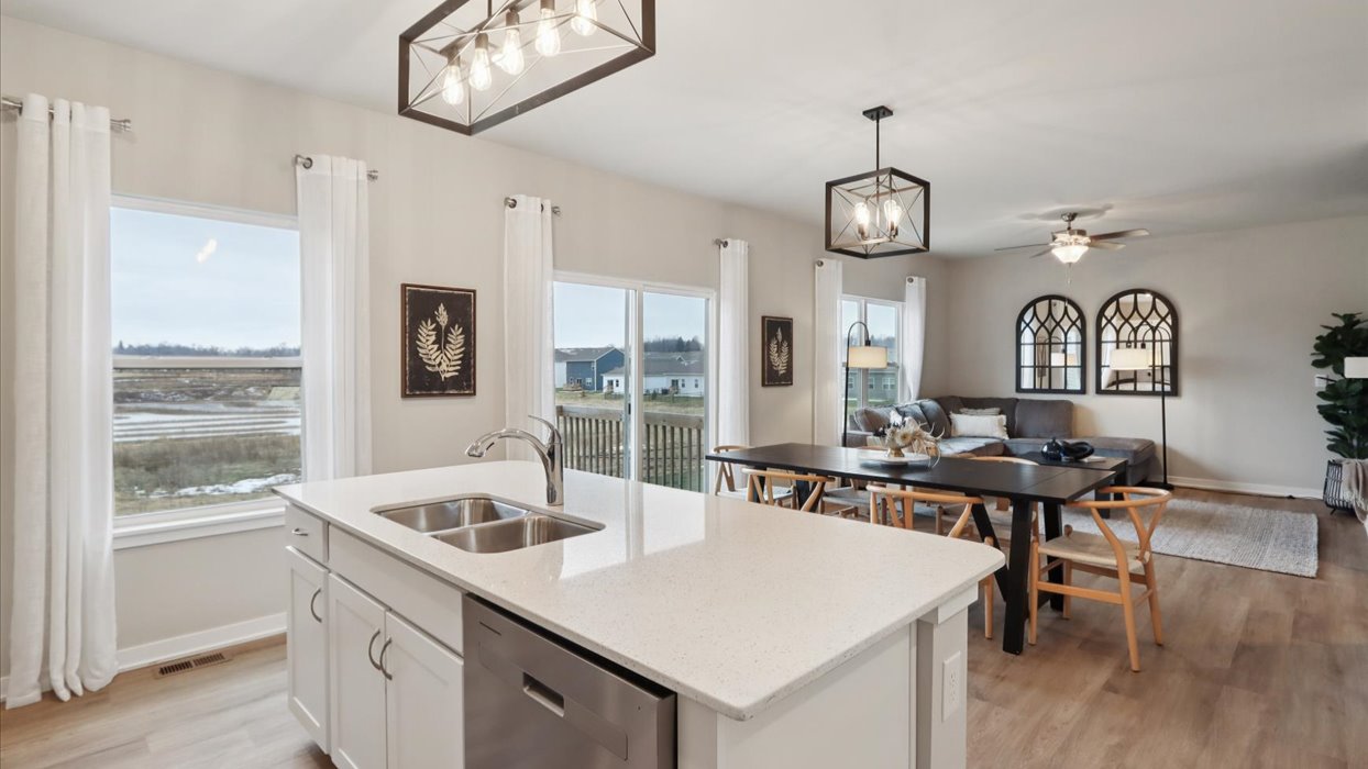 Kitchen with stainless steel appliances, quartz countertops, and white cabinetry