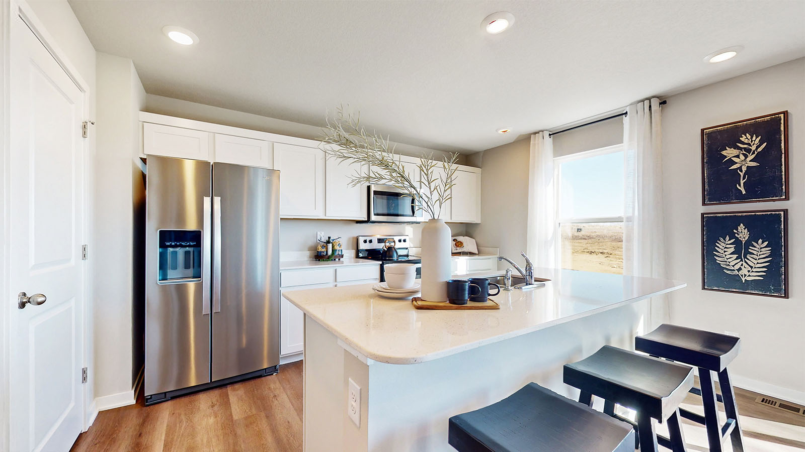 Central kitchen island with sink and seating, appliance suite included, prep zones and pantry access