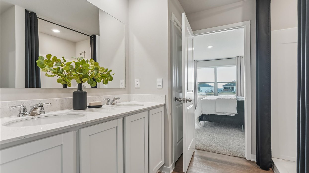 primary bathroom with large mirror and dual sinks