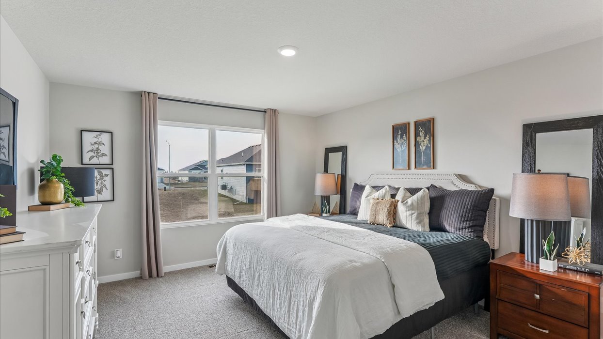 primary bedroom with large window and furniture
