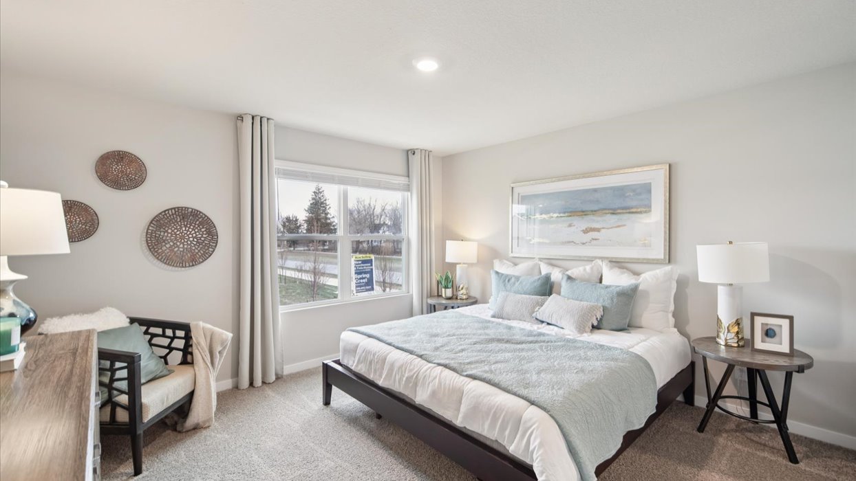 spacious primary bedroom with large window and bed with nightstands