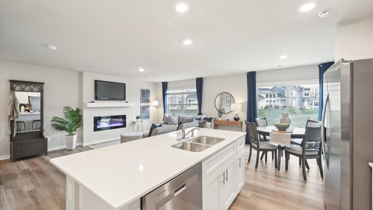 kitchen with island and stainless-steel appliances overlooking living room and dining area