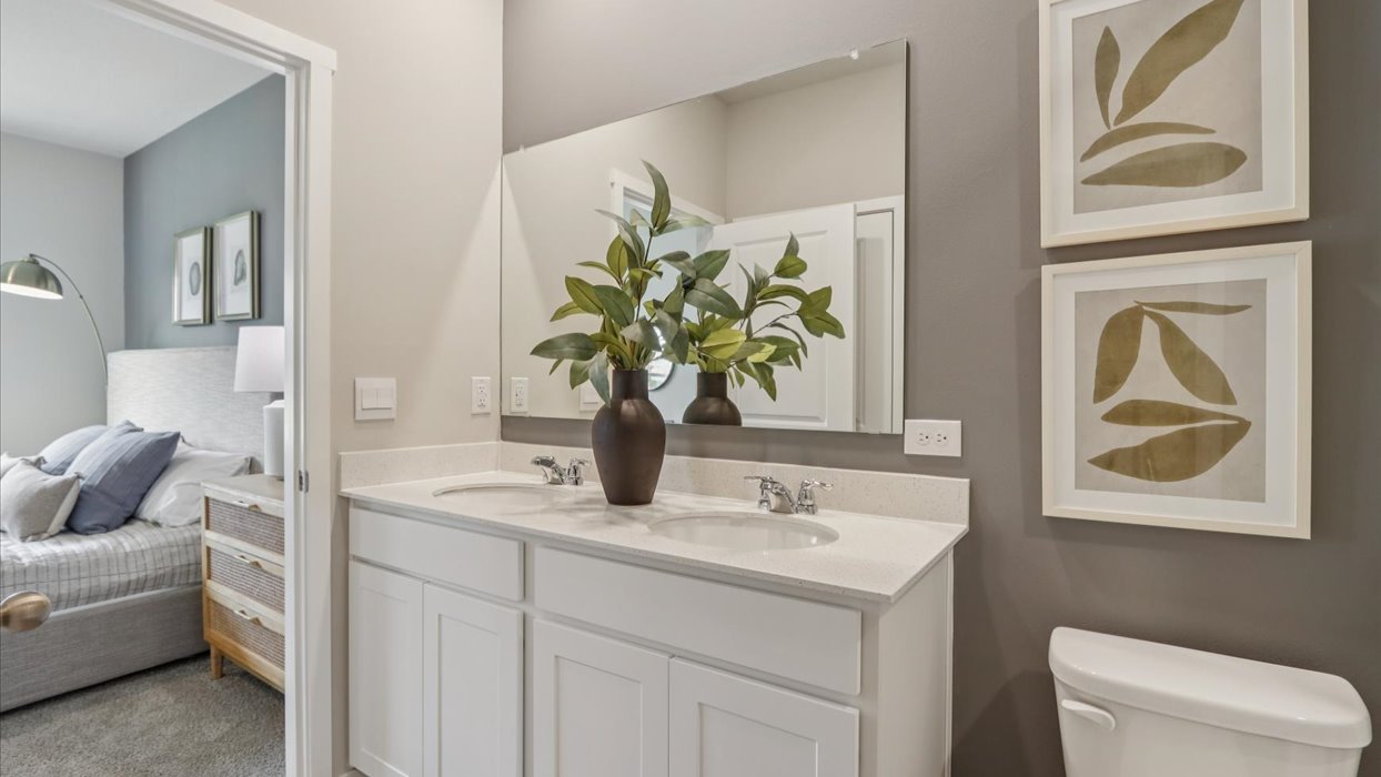 Spacious bathroom with white cabinetry and double sinks