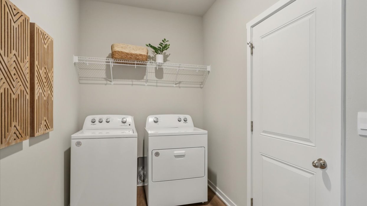 Dedicated laundry room with built-in shelving and utility connections.