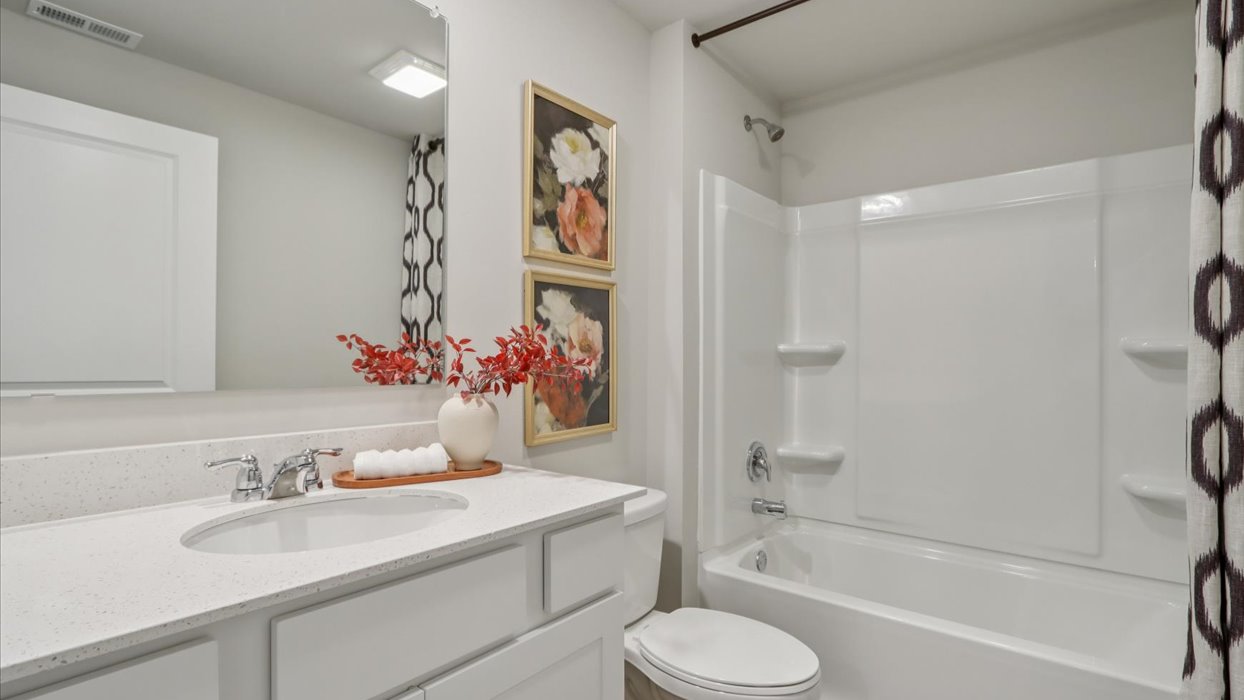 Bathroom with tub and shower combo, quartz countertops, and white vanity