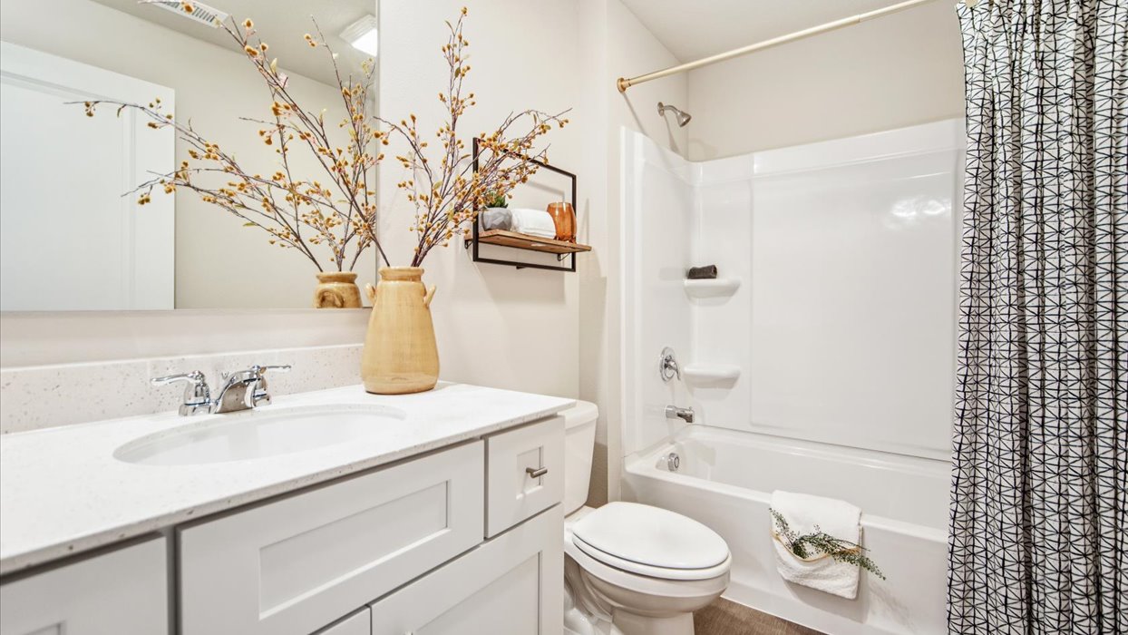 Bathroom with tub and shower combo, quartz countertops, and white vanity