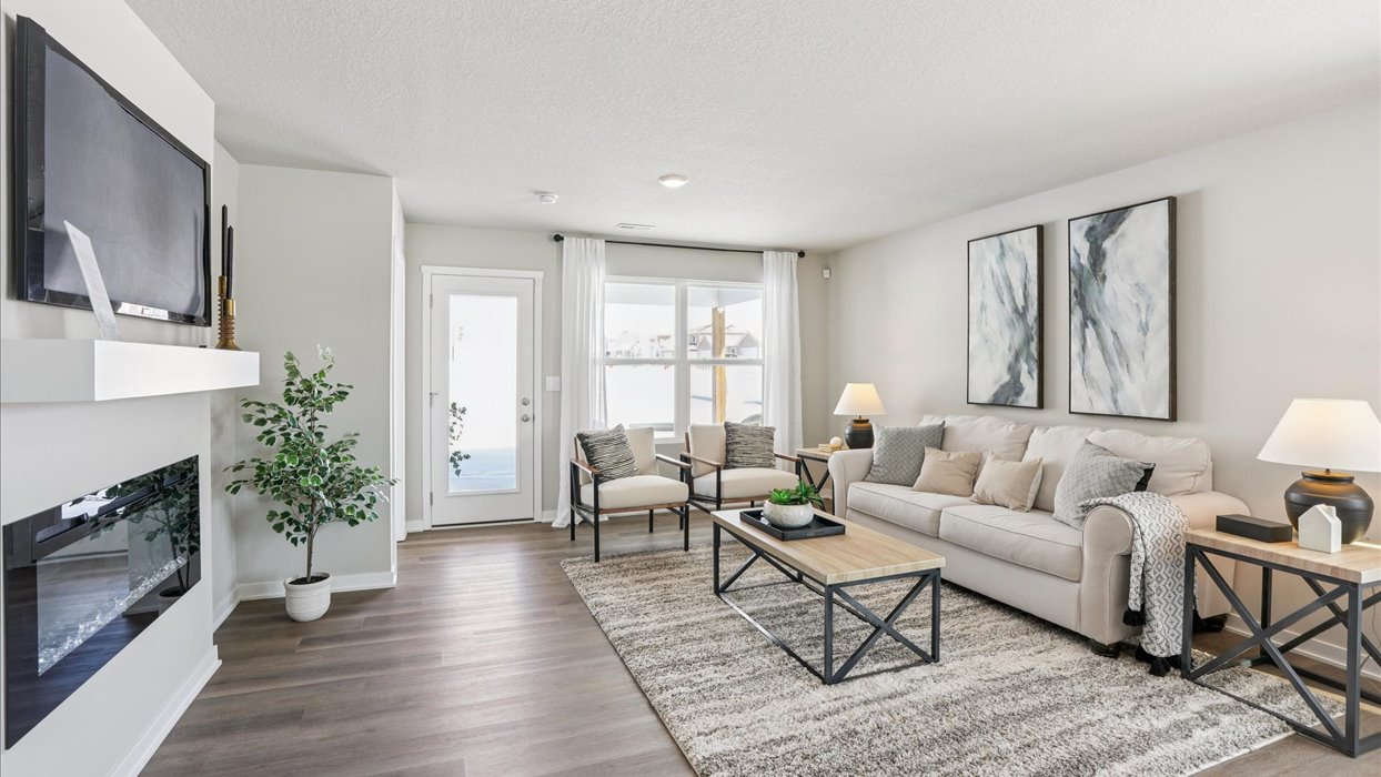 bright living room with large window and electric fireplace