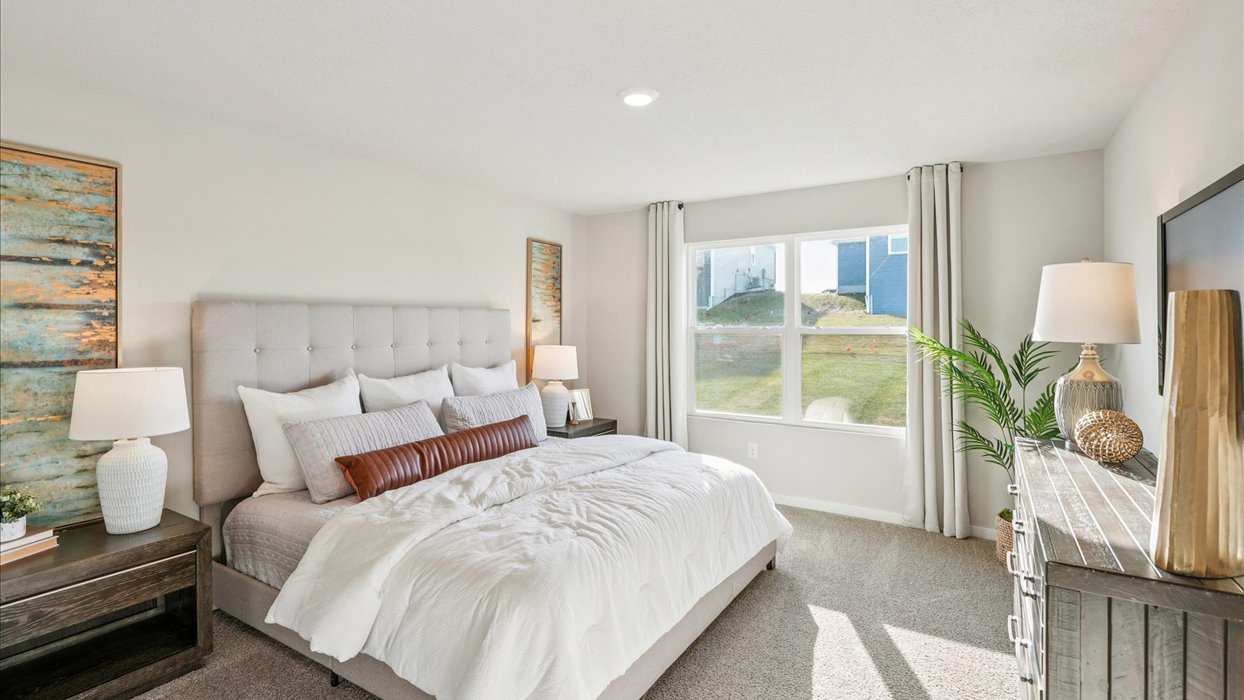 primary bedroom with large mirror and white bed with dresser