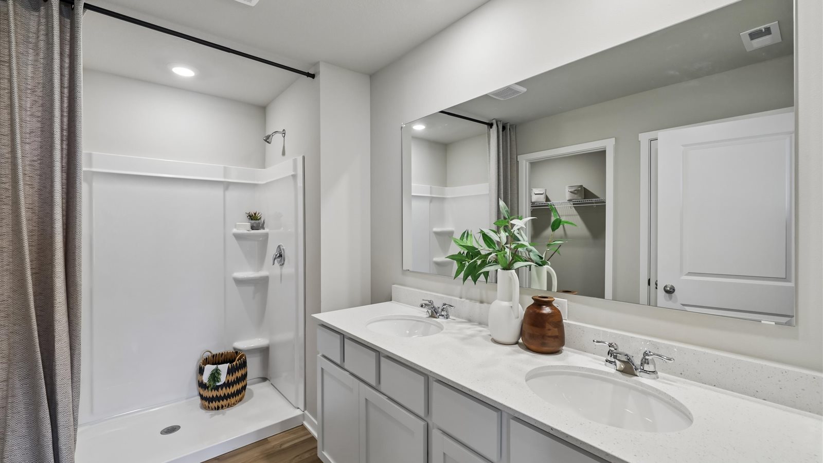 Spacious bathroom with white cabinetry and double sinks