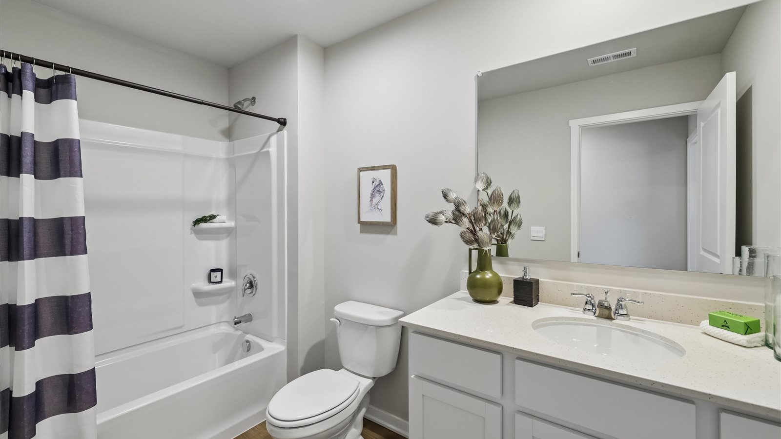 Bathroom with tub and shower combo, quartz countertops, and white vanity